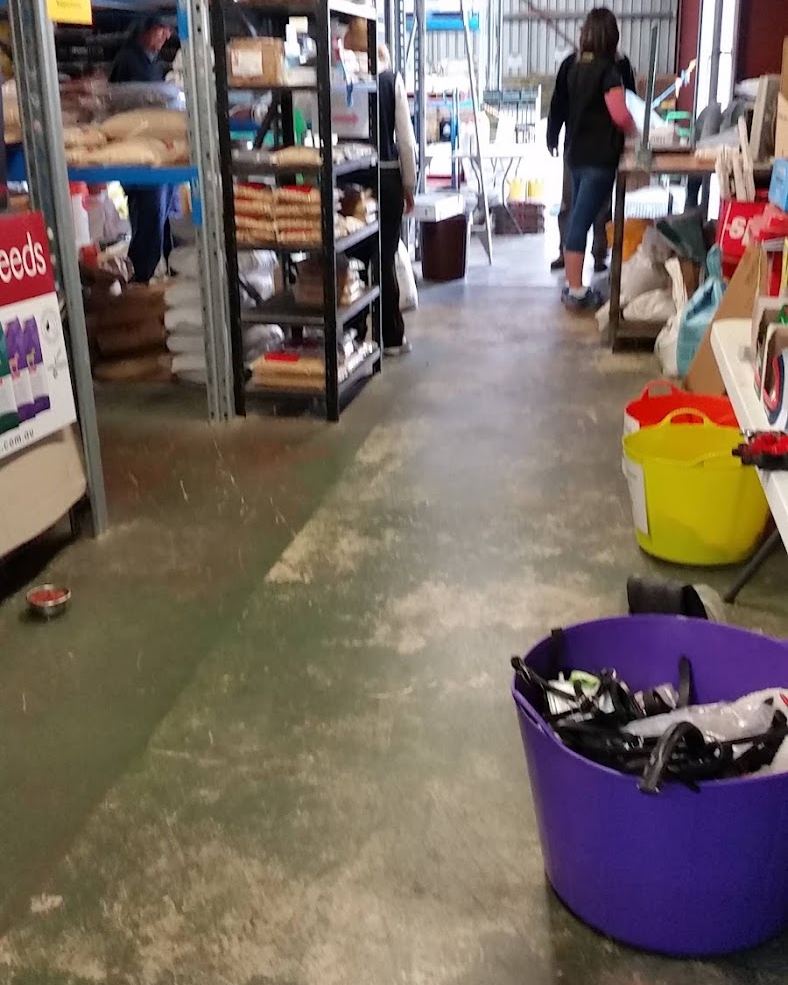 Inside the store: aisles stacked with feed bags and horse gear
